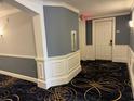 Well-lit condo hallway with detailed trim, patterned carpet, and fire safety equipment at 9994 Beach Club Dr. # 408, Myrtle Beach, SC 29572