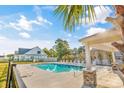 Beautiful swimming pool with clear blue water, a covered patio, and plenty of seating at 1406 Seabrook Plantation Way, North Myrtle Beach, SC 29582