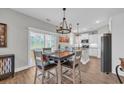 Well-lit dining room with an island in the kitchen, modern chandelier, and backyard views at 3004 Fiddler Ct., Loris, SC 29569