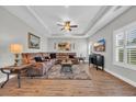 Spacious living room with a large sectional couch, tray ceilings, and wood flooring at 3004 Fiddler Ct., Loris, SC 29569