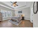 Cozy main bedroom with trey ceilings, a ceiling fan, and natural light from the large windows at 3004 Fiddler Ct., Loris, SC 29569