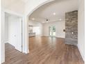 Open-concept living room with hardwood floors and a stone fireplace at 348 Autumn Pheasant Loop, Calabash, NC 28467