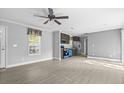 Bright, open floor plan features new gray vinyl flooring and a modern ceiling fan at 103 Off Shore Dr., Murrells Inlet, SC 29576