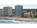 Bright aerial view of beach front property, ocean, and white sandy beach complete with beach goers and crashing waves at 107 S Ocean Blvd. # 1201, Myrtle Beach, SC 29577