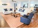 Cozy living room with hardwood floors, white sofas with patterned pillows, and a view of the kitchen at 1114 S Dogwood Dr., Surfside Beach, SC 29575