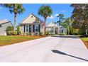 Inviting one-story home featuring a well-manicured lawn, tall palms, and a wide concrete driveway at 141 Wickham Ct., Pawleys Island, SC 29585