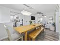 Bright dining area featuring a wooden table and benches, with modern light fixture and view to kitchen and living room at 1512 S Ocean Blvd., North Myrtle Beach, SC 29582