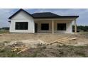 New construction with a modern farmhouse design, black windows, and a covered patio with support columns at 204 Shady Pines Ct., Conway, SC 29527