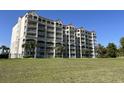 Exterior side view of the Mediterranean-style condo building with multiple balconies and a grassy lawn area at 2151 Bridgeview Ct. # 3-305, North Myrtle Beach, SC 29582