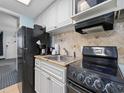Compact kitchen with stainless steel sink, white cabinets, and black appliances at 2401 S Ocean Blvd. S # 1256, Myrtle Beach, SC 29577