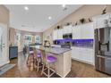Modern kitchen with a granite island, stainless steel appliances, and a dining area with lots of light at 254 Tall Palms Way, Little River, SC 29566