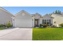 Charming single-story home featuring a two-car garage and well-manicured lawn at 363 Cypress Springs Way, Little River, SC 29566