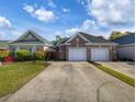 View of the home's exterior showing the two-car garage, driveway, and manicured lawn at 400 Woodpecker Ln. # 17B, Murrells Inlet, SC 29576