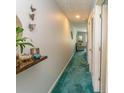 Long carpeted hallway with decoratively furnished shelf and view of the living room at 646 Tupelo Ln. # 4E, Longs, SC 29568
