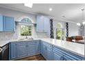 Bright kitchen with blue cabinets, white countertops, and stainless steel sink at 679 Riverwalk Dr. # 201, Myrtle Beach, SC 29579