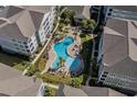 Aerial view of the community pool surrounded by lush landscaping, lounge chairs, and several buildings at 800 Monarch Dr. # 46, Myrtle Beach, SC 29588