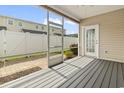 Relaxing screened-in patio with gray wood flooring and a view of the fenced backyard at 800 Monarch Dr. # 46, Myrtle Beach, SC 29588