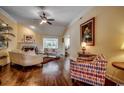 Cozy living room with hardwood floors, a ceiling fan, fireplace and large windows for natural light at 8261 Timber Ridge Rd., Conway, SC 29526
