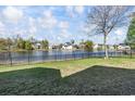 Expansive backyard with lush green grass, a black fence, and serene lake views at 1006 Surf Pointe Dr., North Myrtle Beach, SC 29582