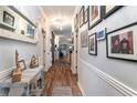 Hallway features wood-look flooring, decor table, mirror, and framed photos on the walls at 101 Maddington Place Dr. # 103, Surfside Beach, SC 29575