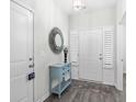 Inviting foyer with white walls, wood-look floors, a decorative mirror, and a console table at 1239 Pyxie Moss Dr., Little River, SC 29566