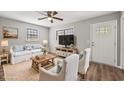 Cozy staged living room with light colored sofa and chairs and lots of light from windows at 2939 King St., Loris, SC 29569