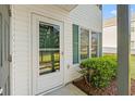 Charming condo entrance featuring a glass door, green shutters, and well-maintained landscaping at 820 Fairway Dr. # 1506Hh, Longs, SC 29568