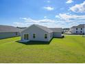 Expansive backyard with lush green lawn and a view of neighboring homes under a bright sky at 1106 Cherrystone Loop, Conway, SC 29526