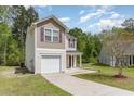 Charming two-story home featuring an attached garage, concrete driveway, and well-maintained landscaping at 113 Winding Path Dr., Loris, SC 29569