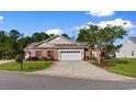 Inviting single-story home with brick accents, a two-car garage, and a beautifully landscaped yard, creating an attractive curb appeal at 120 Carolina Crossing Blvd., Little River, SC 29566