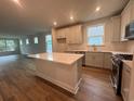Open-concept kitchen featuring an island, stainless steel appliances, and hardwood floors at 1209 Lady Bird Way, North Myrtle Beach, SC 29582
