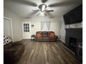 Comfortable living room features a cozy leather sofa, black fireplace, and natural light from a front door at 211 Amber Dr., Marion, SC 29571