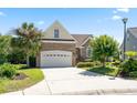 Attractive two-story home featuring a brick facade, lush landscaping, and a two-car garage on a sunny day at 2213 Gazebo Ct., North Myrtle Beach, SC 29582