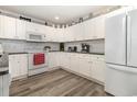 Bright kitchen featuring white cabinets, granite counters, a white appliance suite, and stylish wood-look floors at 2406 S Ocean Blvd. # 301, North Myrtle Beach, SC 29582
