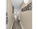 Hallway with laminate floors leading to a room with a blue print above the doorway at 2711 Ocean Blvd. S # 915, North Myrtle Beach, SC 29582