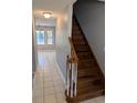 Inviting hallway with hardwood stairs, white tile flooring, and views into the dining area at 302 St. Andrews Ln., Myrtle Beach, SC 29588