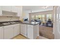 Bright kitchen with white cabinets, stainless sink, and open view to the living area at 3943 Gladiola Ct. # 202, Myrtle Beach, SC 29588
