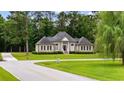 Attractive one-story brick home boasting mature trees, a lovely lawn and a circular driveway at 4100 Hagwood Circle, Conway, SC 29526