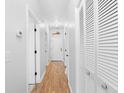 Bright, neutral hallway with wood-look floors, white doors, and closet with shell-style knobs at 4518 N Planatation Harbour Dr. # G-17, Little River, SC 29566