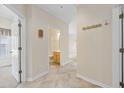 Hallway with tile floors leading to a bathroom and bedroom, showcasing neutral walls and coat hooks at 5882 Longwood Dr. # 201, Murrells Inlet, SC 29576