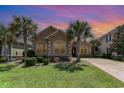 Charming single-story home featuring a well-manicured lawn, mature palm trees, and a welcoming facade at sunset at 7041 Turtle Cove Dr., Myrtle Beach, SC 29579