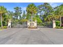 Grand gated entrance to the community with manicured landscaping and mature palm trees at 809 Covelo Ln., Myrtle Beach, SC 29579