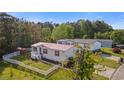 Aerial view of a well-maintained home with a red roof, surrounded by a fenced yard and lush greenery at 8404 Bloomwood Dr., Myrtle Beach, SC 29588