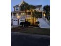 Charming elevated home with three-car garage, accessed by large staircase with palm trees at 9 Gasparilla Circle, Murrells Inlet, SC 29576