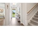 Bright foyer with wood floors, staircase, console table, and front door view to a well-manicured lawn at 5000 Azul Loop, Myrtle Beach, SC 29579