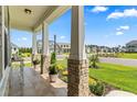 Inviting front porch with stately columns, potted plants, and a view of the neighborhood street at 5000 Azul Loop, Myrtle Beach, SC 29579