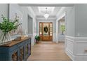 Elegant foyer showcasing a chandelier, wooden floors, and wainscoting, creating a grand entrance at 1001 James Island Ave., North Myrtle Beach, SC 29582