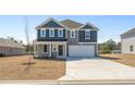 Charming two-story home with a blue and grey exterior and a well-manicured lawn at 1028 Kinness Dr., Conway, SC 29527