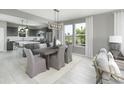 Dining area with modern chandelier, large windows, and adjacent kitchen space at 1213 Lady Bird Way, North Myrtle Beach, SC 29582