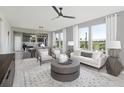 Spacious living room featuring neutral décor, large windows, and modern ceiling fan at 1213 Lady Bird Way, North Myrtle Beach, SC 29582